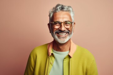 Obraz premium Portrait of a happy senior man in glasses on a pink background