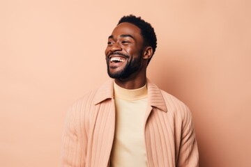 Portrait of a happy african american man laughing isolated over beige background