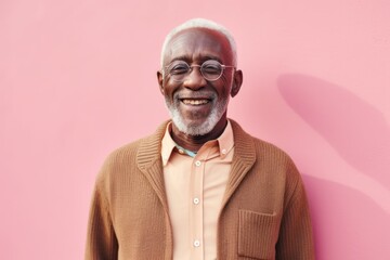 Obraz premium Portrait of senior african american man smiling against pink background