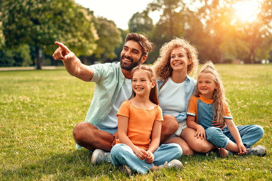 Happy Family Relaxing In The Park