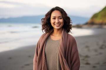 Group portrait of a Indonesian woman in her 30s in a beach background wearing a cozy sweater