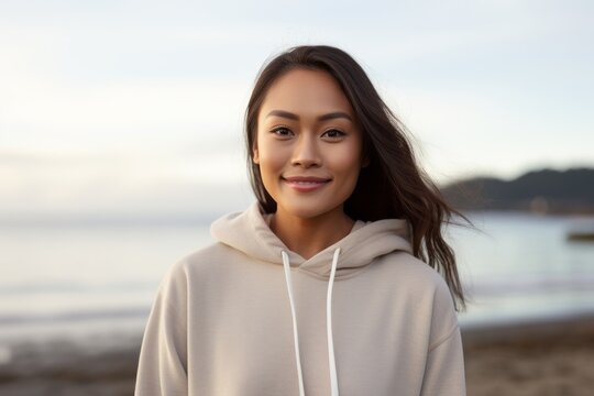 Lifestyle portrait of a Indonesian woman in her 30s in a beach background wearing a cozy sweater