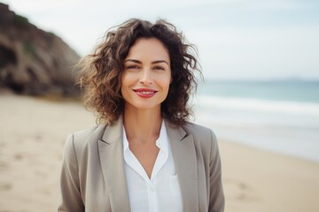 Lifestyle portrait of a Brazilian woman in her 40s in a beach background wearing a classic blazer