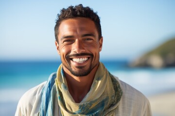 Lifestyle portrait of a Brazilian man in his 30s in a beach background wearing a charming scarf