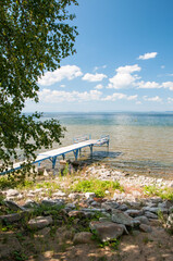 Lake Uvildy in summer with a pier on its rocky shore, South Urals, Russian Federation