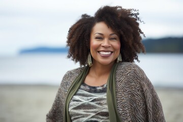 Group portrait of a Nigerian woman in her 30s in a beach background wearing a chic cardigan