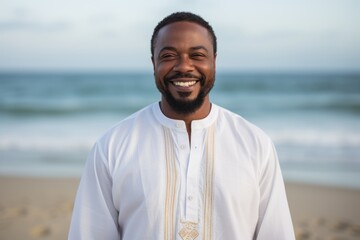 Lifestyle portrait of a Nigerian man in his 40s in a beach background wearing a simple tunic