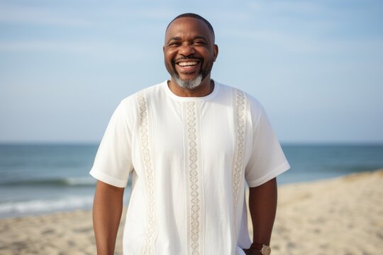 Lifestyle portrait of a Nigerian man in his 40s in a beach background wearing a simple tunic