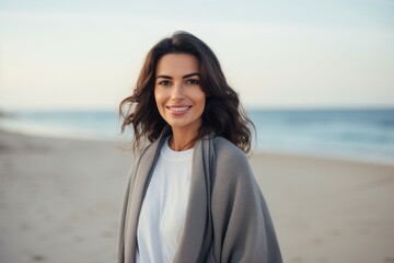 Medium shot portrait of a Saudi Arabian woman in her 30s in a beach background wearing a chic cardigan