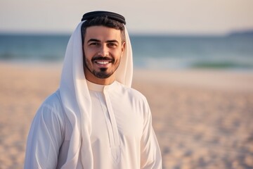 Fototapeta premium Portrait of young arabian man smiling at camera on the beach