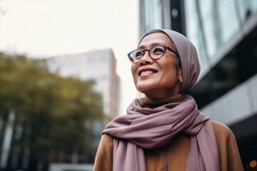 smiling african american woman in hijab looking away in city
