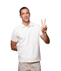 Young man making a number two gesture