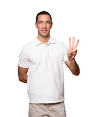 Young man making a number three gesture