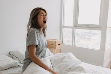 Funny face sleepy head asian woman just wake up in the morning dizzy and lazy.