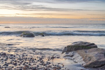Aerial view of sea waves breaking beach during sunset