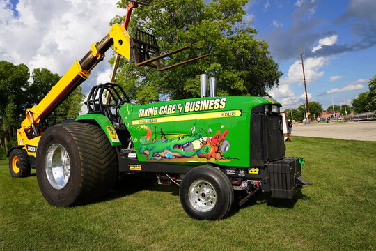 Modified John Deere power tractor for power pulling competition sits on the roadside.