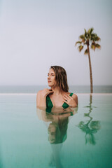 Chica joven delgada posando y descansando en piscina de hotel de lujo en andalucia