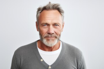 Portrait of mature man with grey hair looking at camera over white background
