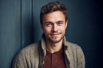 Obraz premium Portrait of a handsome young man in a sweater looking at camera