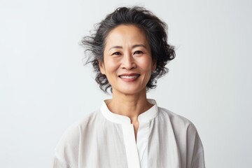 Portrait of a happy mature asian woman smiling over white background