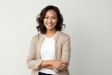 Obraz premium Portrait of a smiling asian businesswoman standing with arms crossed over white background