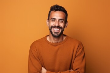 Obraz premium Portrait of a happy young man standing with arms crossed over yellow background