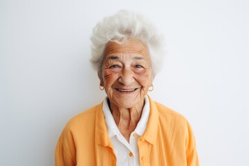 Portrait of a happy senior woman smiling at camera while standing against white background