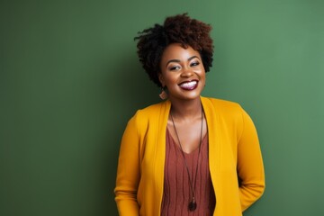 Portrait of a smiling african american woman standing against green background