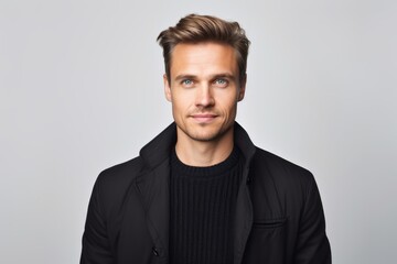 Fototapeta premium Portrait of handsome young man in black jacket looking at camera.