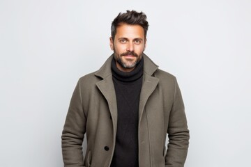 Obraz premium Portrait of a handsome man in coat and scarf on white background