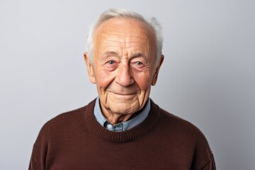 Portrait of a senior man looking at the camera on a gray background