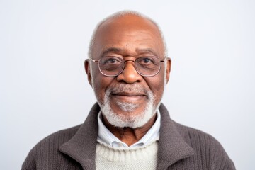 Portrait of a Nigerian man in his 70s in a white background wearing a chic cardigan