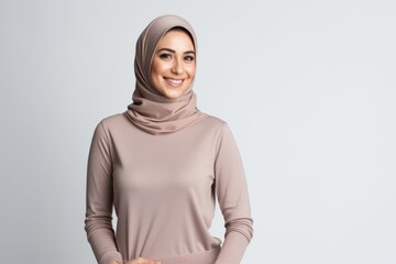 Portrait of a Saudi Arabian woman in her 30s in a white background wearing a cozy sweater