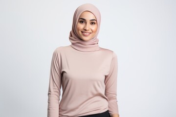Fototapeta premium Portrait of a Saudi Arabian woman in her 30s in a white background wearing a cozy sweater