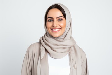 Portrait of a Saudi Arabian woman in her 30s in a white background wearing a chic cardigan