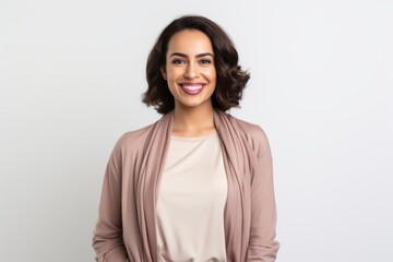 Fototapeta premium Portrait of a Saudi Arabian woman in her 30s in a white background wearing a chic cardigan