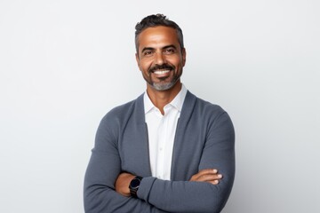 Portrait of handsome Indian man with crossed arms looking at camera and smiling