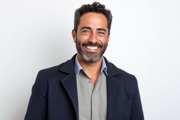 Portrait of a handsome Hispanic man smiling at the camera while standing against white background