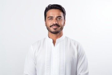 Portrait of a Saudi Arabian man in his 30s in a white background wearing a chic cardigan