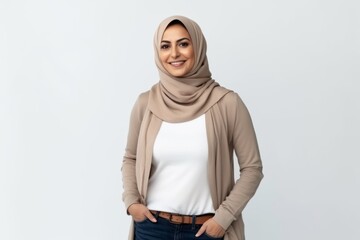 Fototapeta premium Medium shot portrait of a Saudi Arabian woman in her 40s in a white background wearing a chic cardigan
