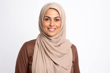 Portrait of a Saudi Arabian woman in her 40s in a white background wearing a chic cardigan