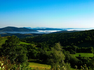 hilly field with clouds peeking out