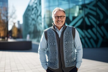 Portrait of a Russian man in his 50s in a modern architectural background wearing a chic cardigan - obrazy, fototapety, plakaty