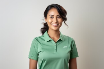 Portrait of a smiling young woman wearing a green polo shirt