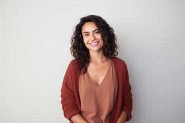 Obraz premium Portrait of a smiling woman standing with hands on hips against white background