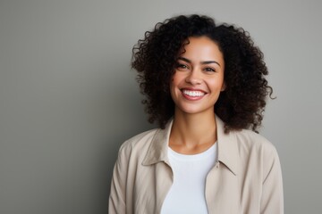 Portrait of a beautiful young african american woman smiling against grey background