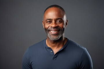 Obraz premium Portrait of a smiling middle-aged African-American man against grey background