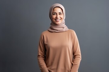 Portrait of happy muslim woman in hijab, isolated on grey background