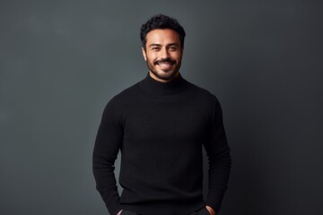 Obraz premium Portrait of a smiling young Indian man standing isolated over grey background