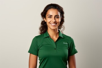 Portrait of beautiful young woman in green polo shirt smiling at camera